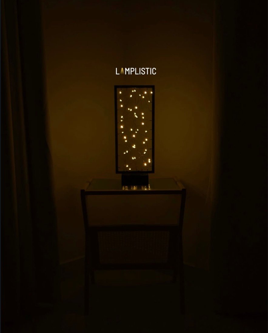 A framed constellation lamp glowing softly in a dark room